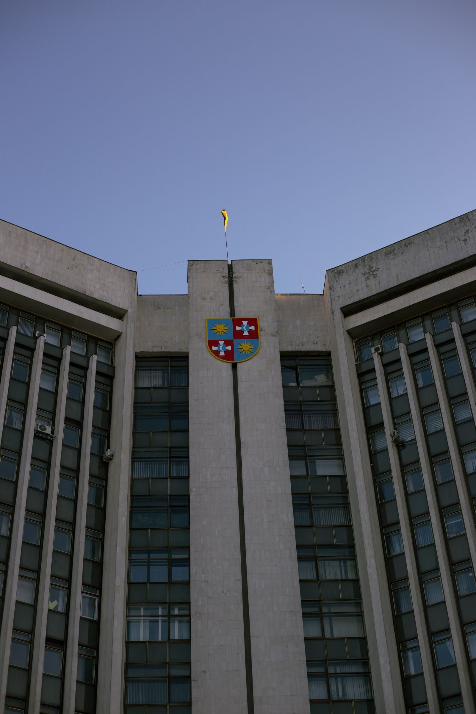 Low-angle view of a government office building with a clear blue sky