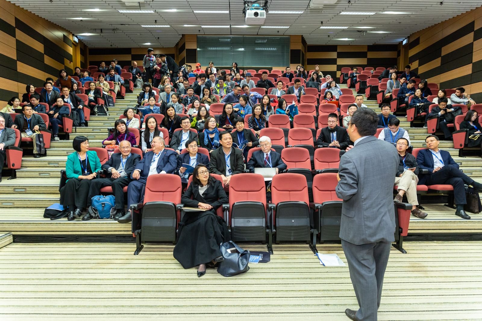 Professional setting of a business conference with attendees and a presenter in an auditorium
