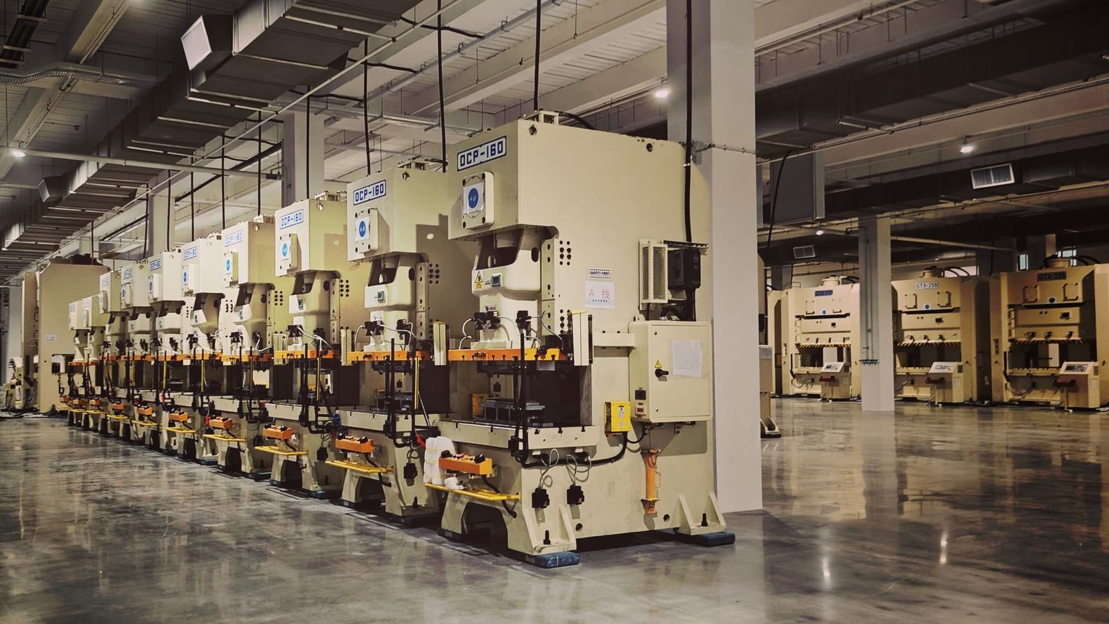 A row of industrial machines on a factory floor, highlighting manufacturing equipment