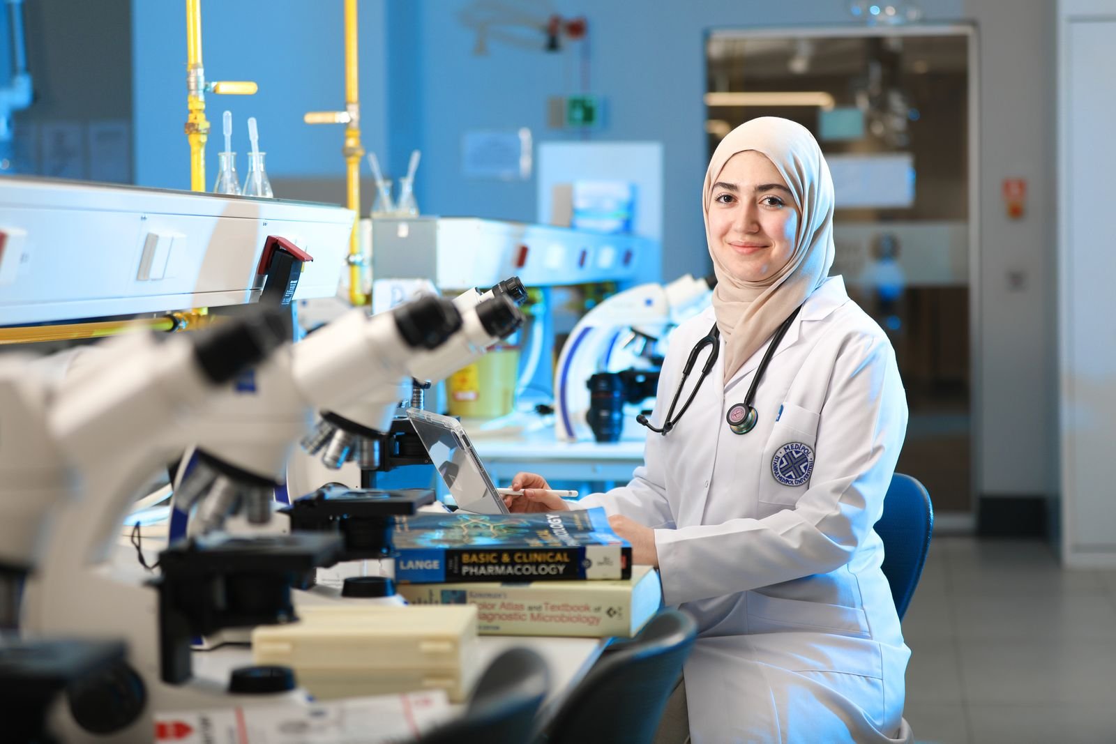 A female scientist in a laboratory setting, conducting research with microscopes and reference books