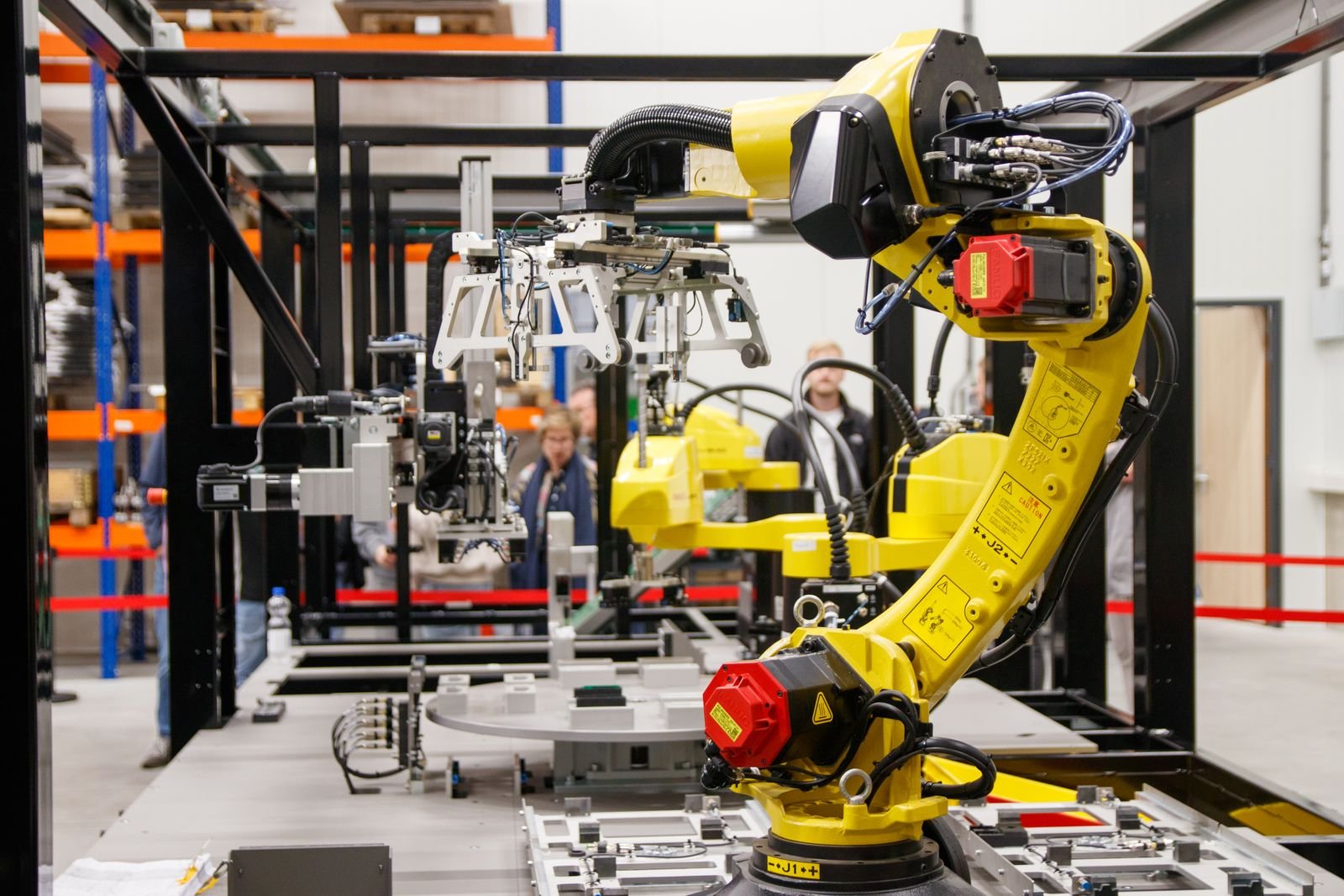 Close-up of a yellow industrial robotic arm in action at a modern manufacturing facility