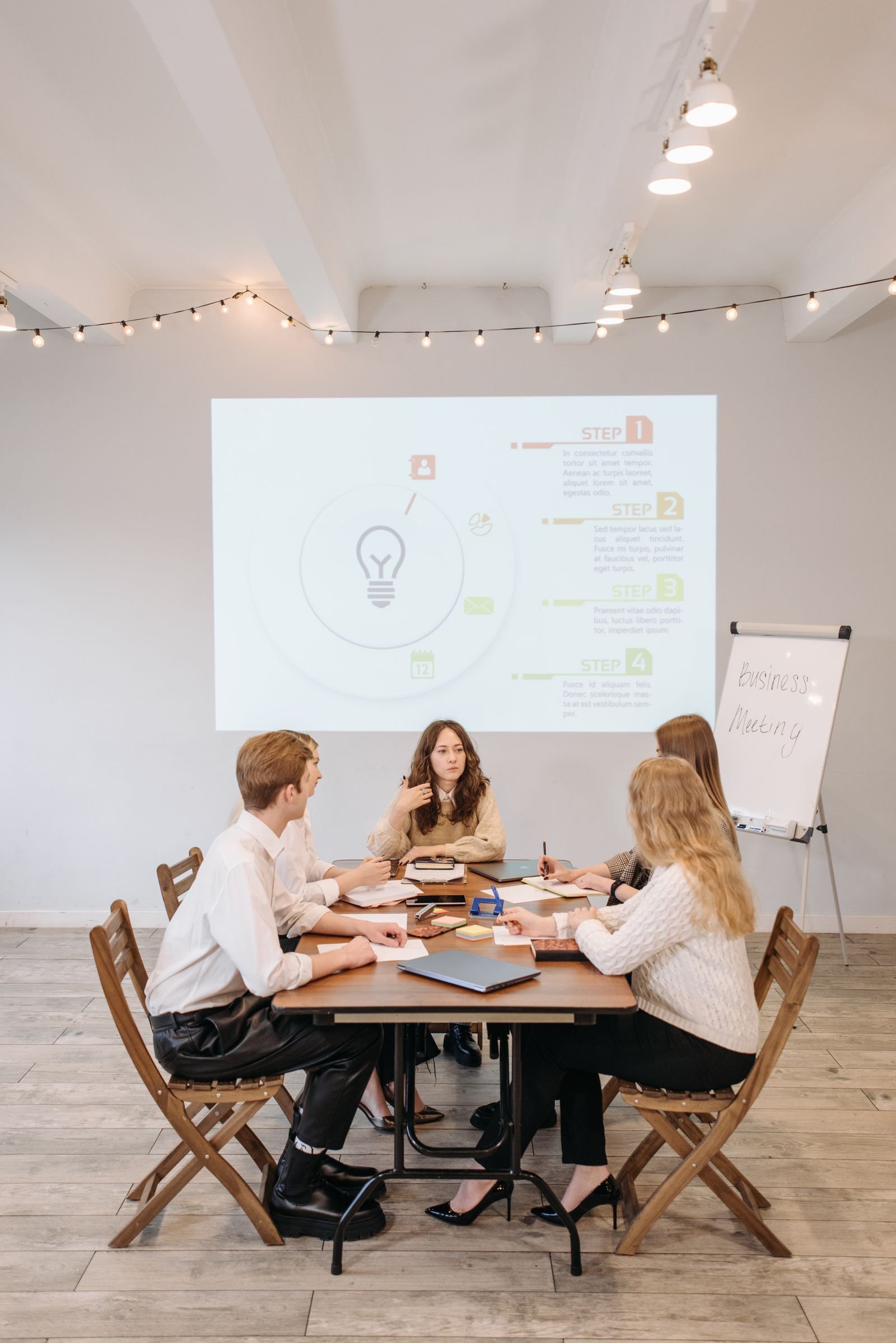 Group of professionals discussing business strategy with a projector and notepad