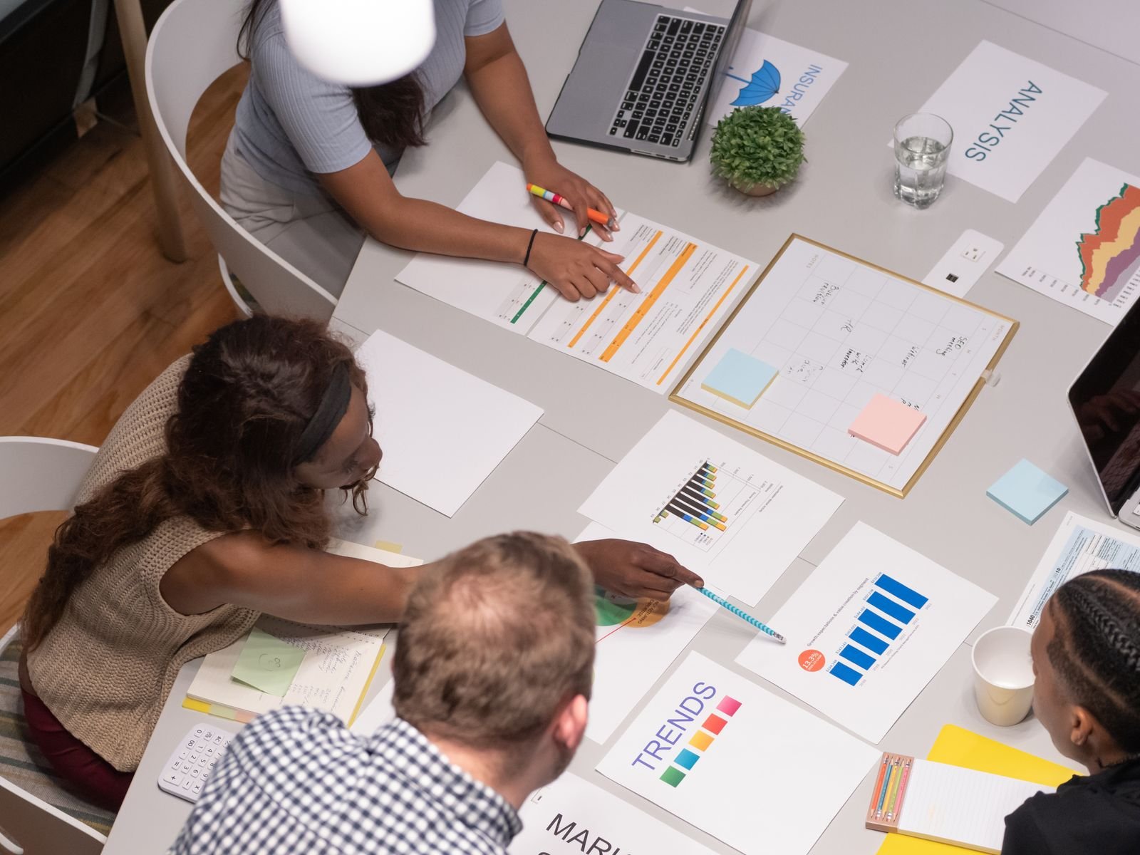 Team of professionals collaborating on a business project, analyzing charts and graphs in an office setting