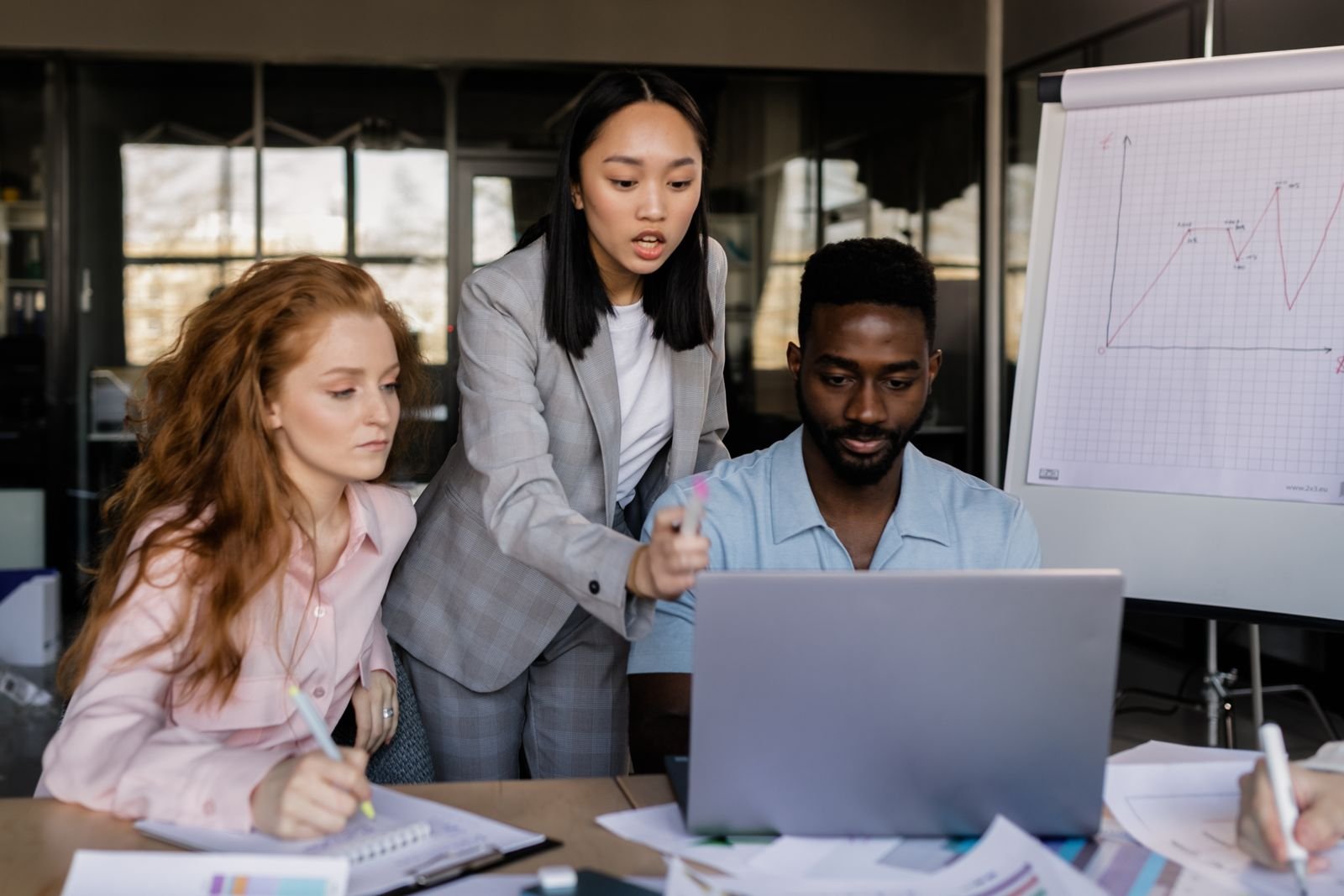 Business team discussing strategy in a modern office setting with diverse members