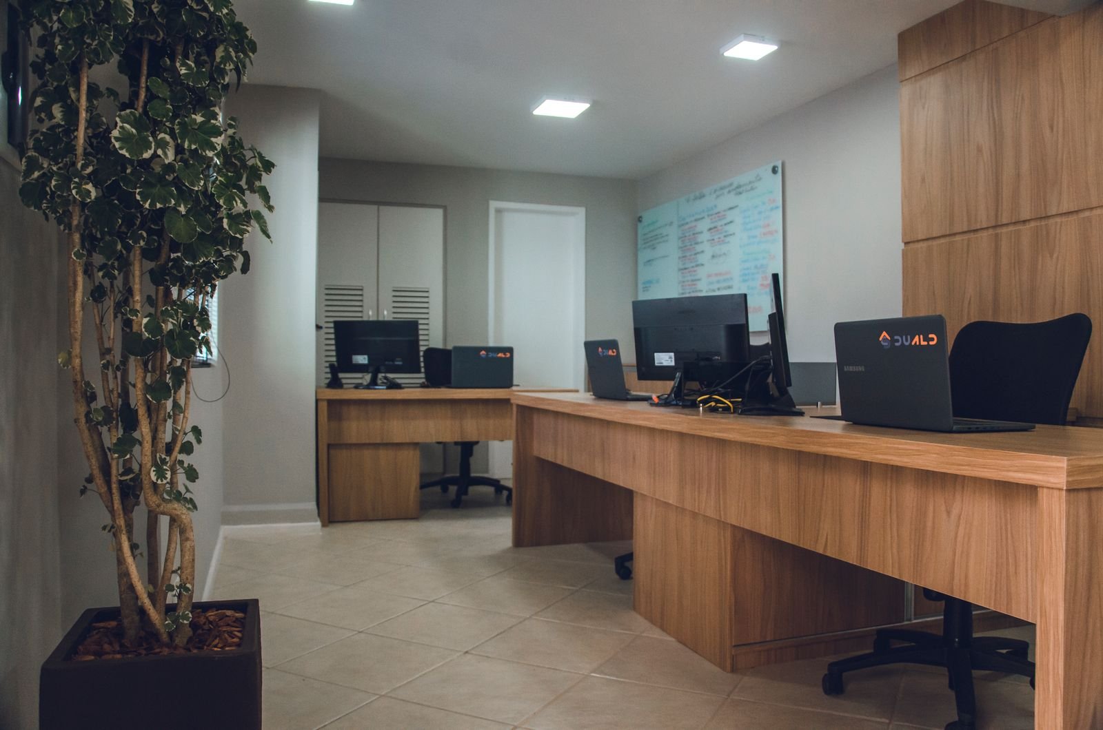 Contemporary office space featuring desks with computers and revolving chairs
