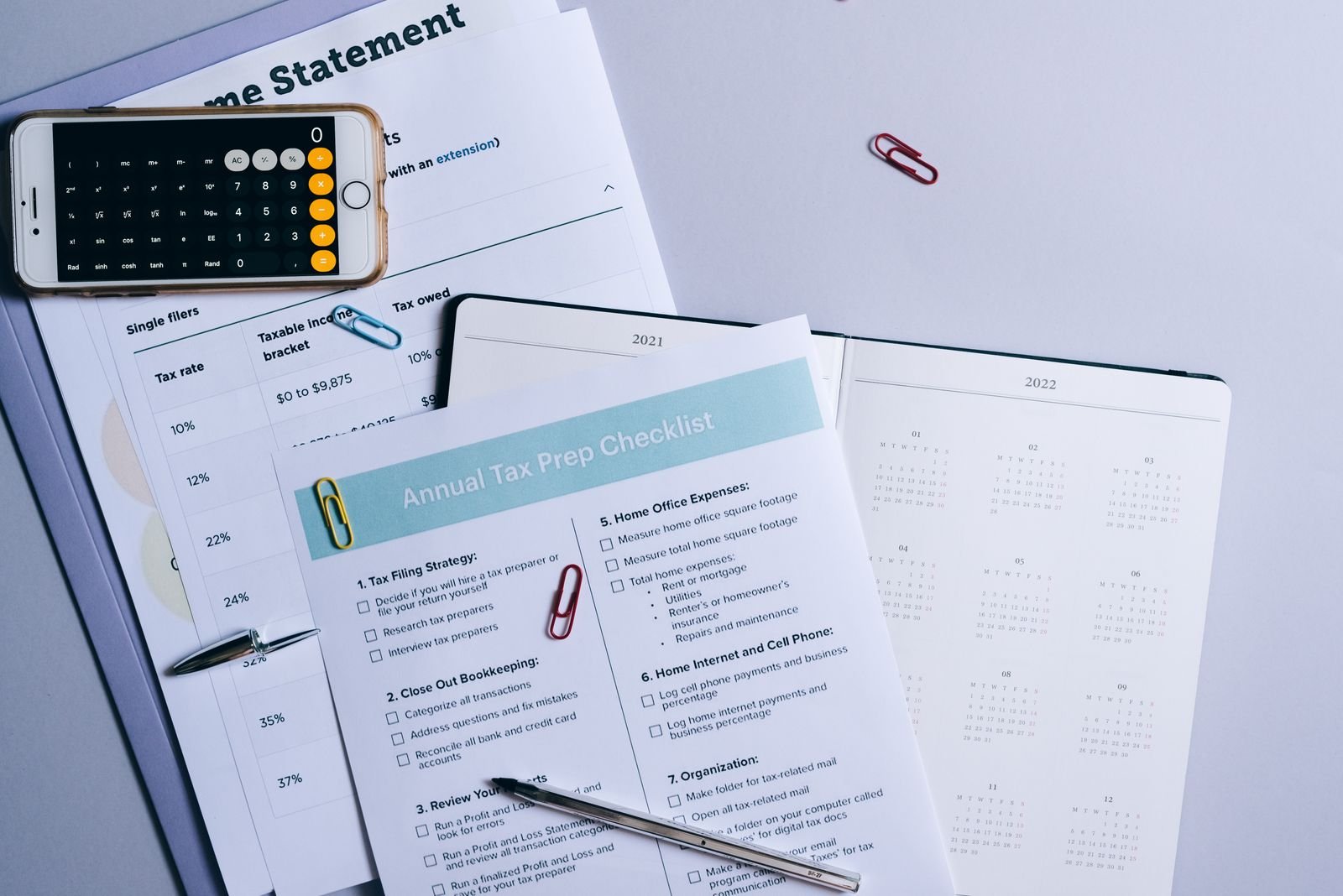 Flat lay of a tax preparation checklist, calculator, and financial documents on a desk